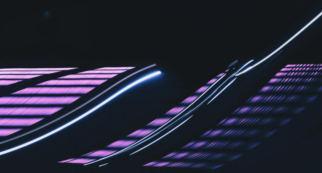 Vibrant abstract image of neon light trails against a dark background.