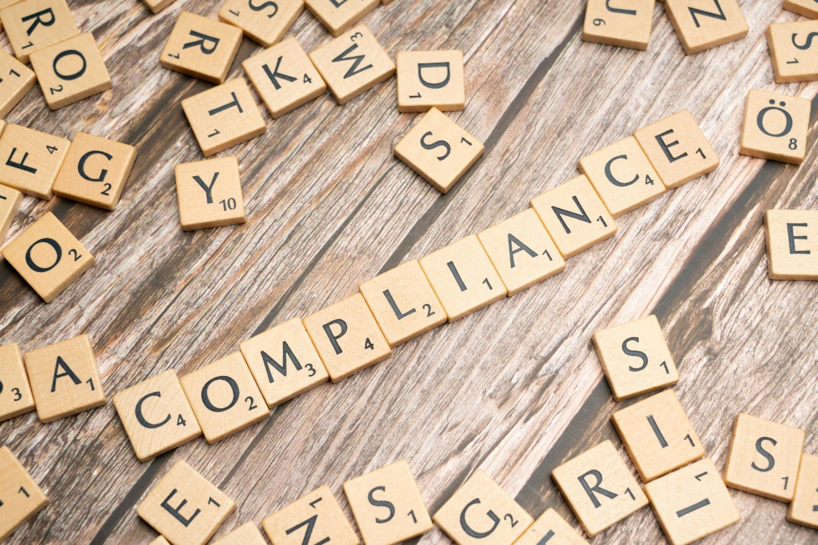 Ilustración de la lista de comprobación de cumplimiento de e-Evidence con fichas de Scrabble que deletrean CUMPLIMIENTO